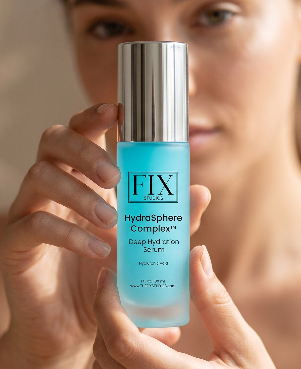 A woman holds a bottle of Fix Studios HydraSphere Complex Hyaluronic Acid Deep Hydration Serum Plums Skin & Reduces Fine Lines