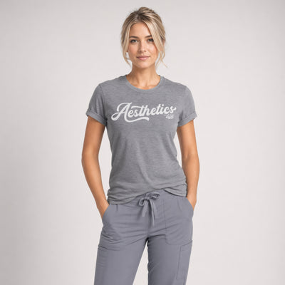 A woman wears a gray Aesthetics Department t-shirt from Fix Studios for medspa professionals, injectors, and medspa fans