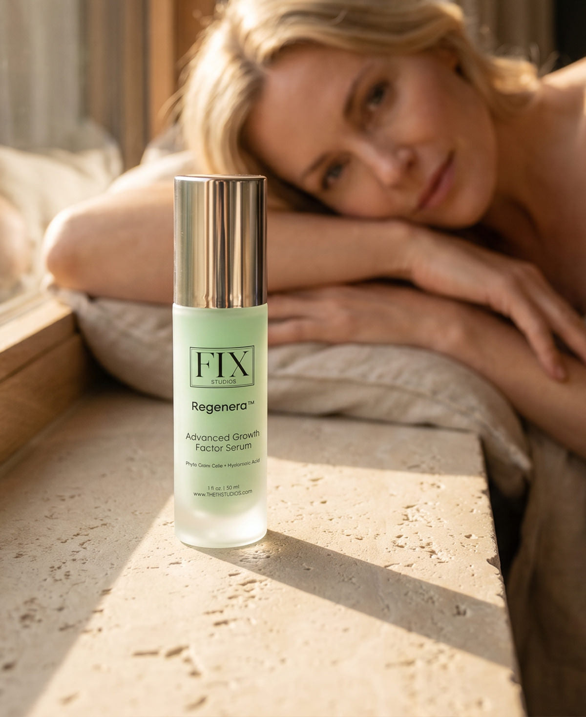 A bottle of Regenera™ Advanced Growth Factor Serum medical-grade anti-aging serum from Fix Studios sits on a window sill with a beautiful woman in the background